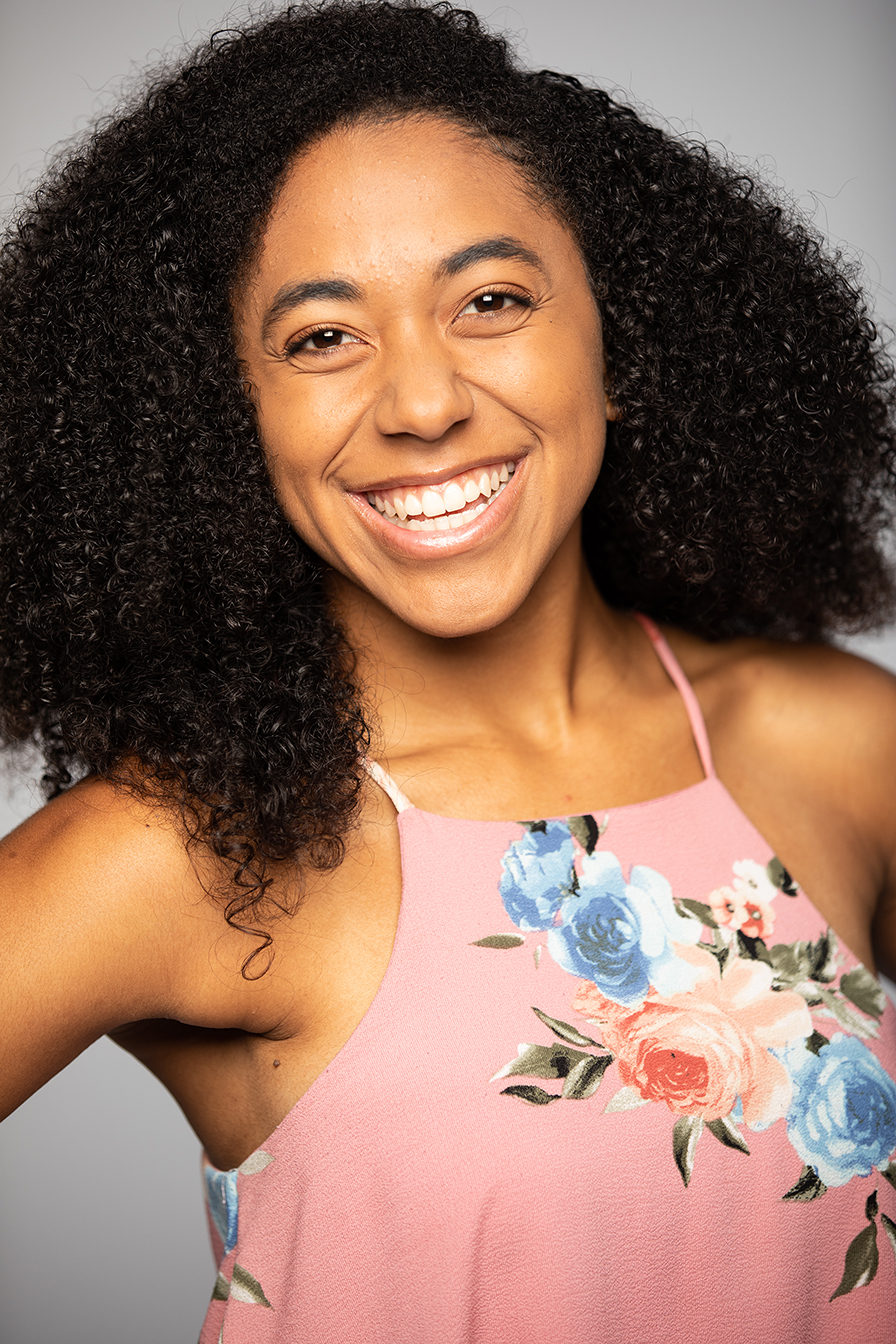 a girl in flowered blouse smiling